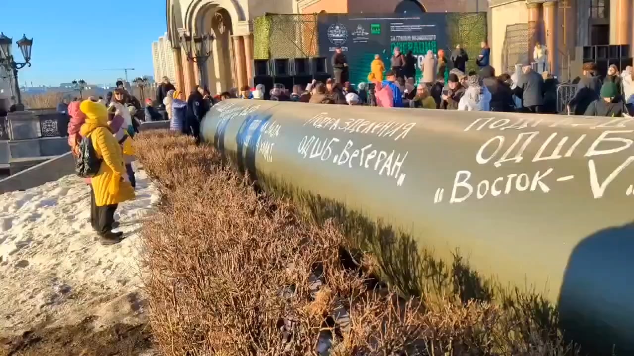 Russians lining up to crawl through the replica of the gas pipeline in which around 800 Russian soldiers were sent to their deaths in last month's failed military operation near Suzdha
