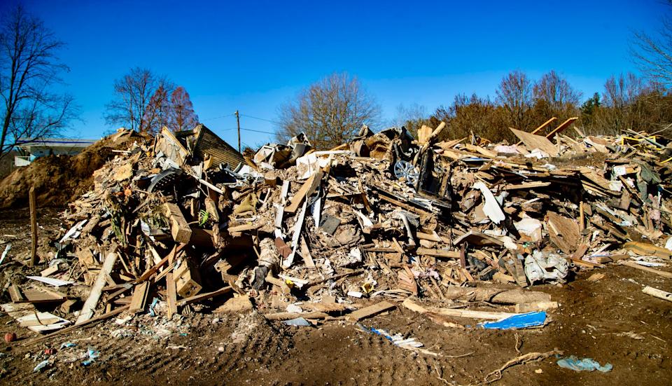 Debris from Tropical Storm Helene sits piled up around Veterans Restoration Quarters by the Swannanoa River Monday, Dec. 23, 2024.