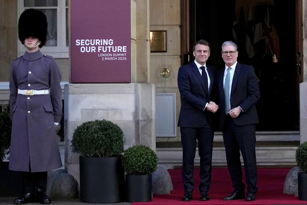 Britain's Prime Minister Keir Starmer, right, greets French President Emmanuel Macron as he arrives for a summit on Ukraine at Lancaster House in London, Sunday, March 2, 2025. (AP Photo/Christophe Ena, Pool)