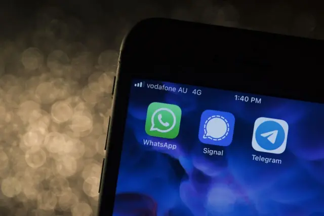 Un celular con las apps WhatsApp, Signal y Telegram