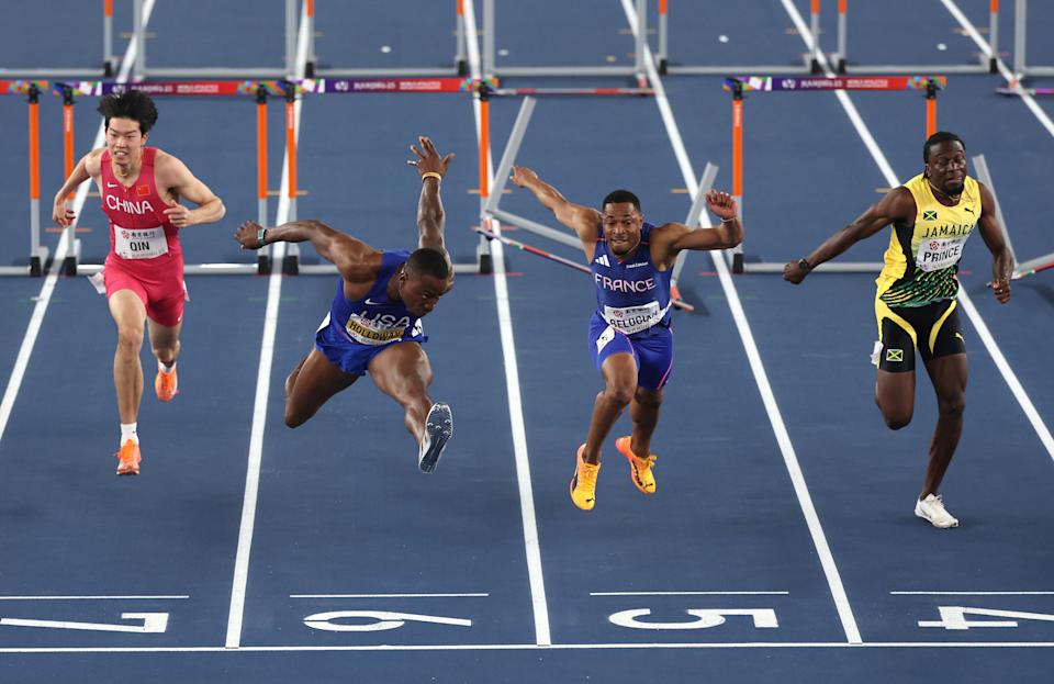 Holloway stretches across the finish line for the victory. (Cameron Spencer/Getty Images)