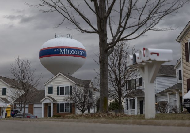 A Minooka water tower is visible behind a subdivision of homes on March 19, 2025, near the site of a proposed data center. "The estimate for Minooka is that by 2070 or maybe 2080, we'll have 50,000 people," said Mayor Offerman. "They're trying to figure out what the water needs are going to be, which, you know, good luck on that." (Brian Cassella/Chicago Tribune)