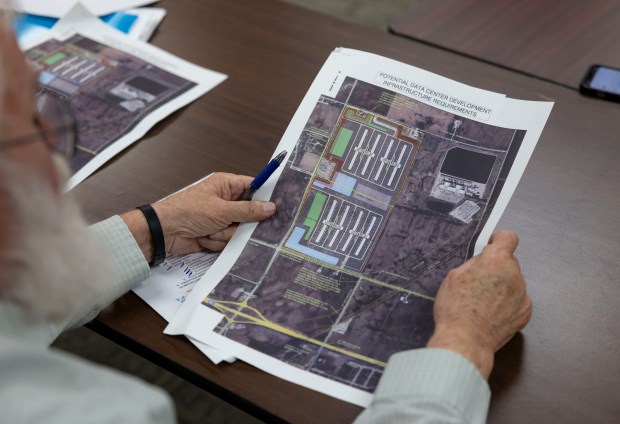 Committee members review documents showing a planned data center by the company Equinix during a Minooka village board committee meeting on March 19, 2025. (Brian Cassella/Chicago Tribune)