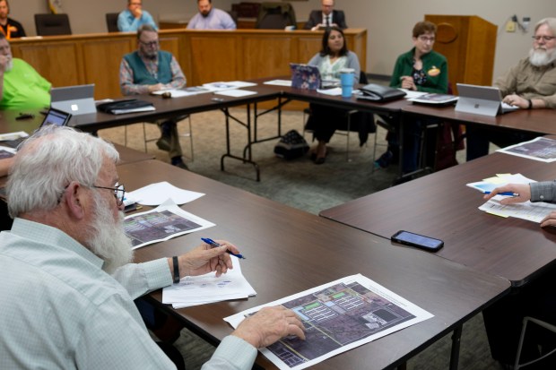 Attendees of the Minooka Village board meeting review documents showing a planned data center by the company Equinix on March 19, 2025. (Brian Cassella/Chicago Tribune)