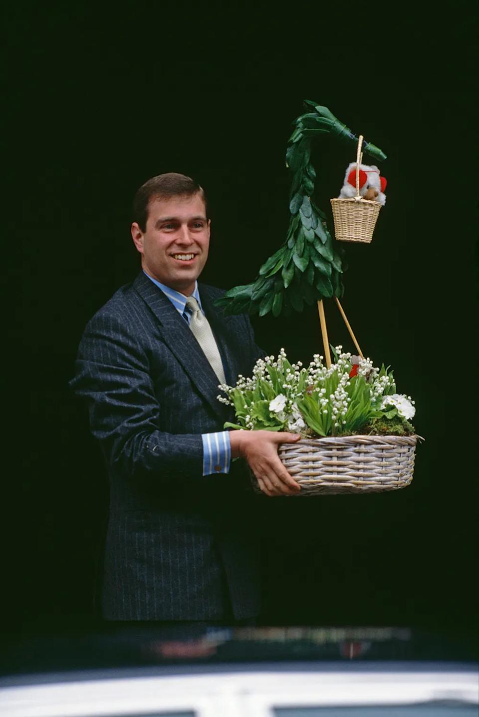 Prince Andrew holding a basket with plants and a teddy bear.