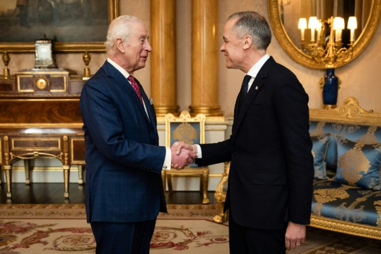 Le roi Charles III (g) serre la main du nouveau Premier ministre canadien Mark Carney en le recevant en audience au palais de Buckingham à Londres, le 17 mars 2025 ( POOL / Aaron Chown )