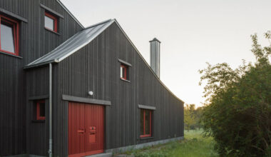 dark wooden facade by ko/ok contrasts existing gabled house