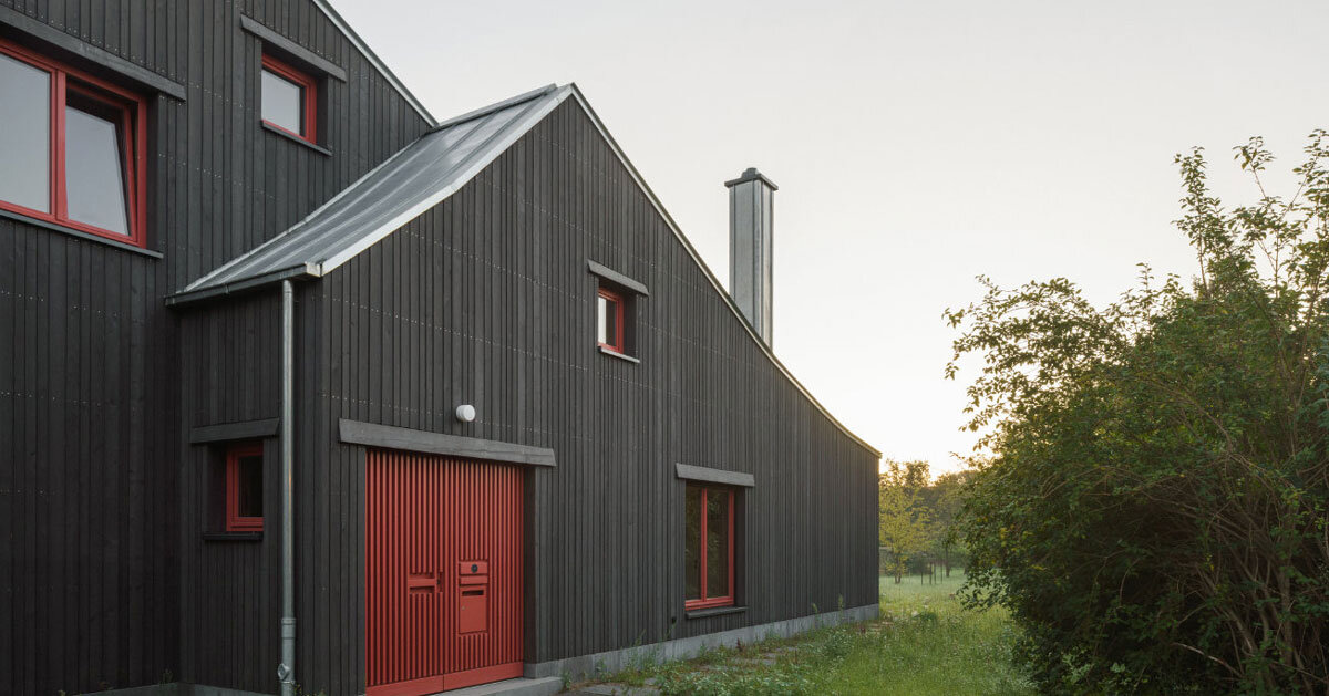 dark wooden facade by ko/ok contrasts existing gabled house