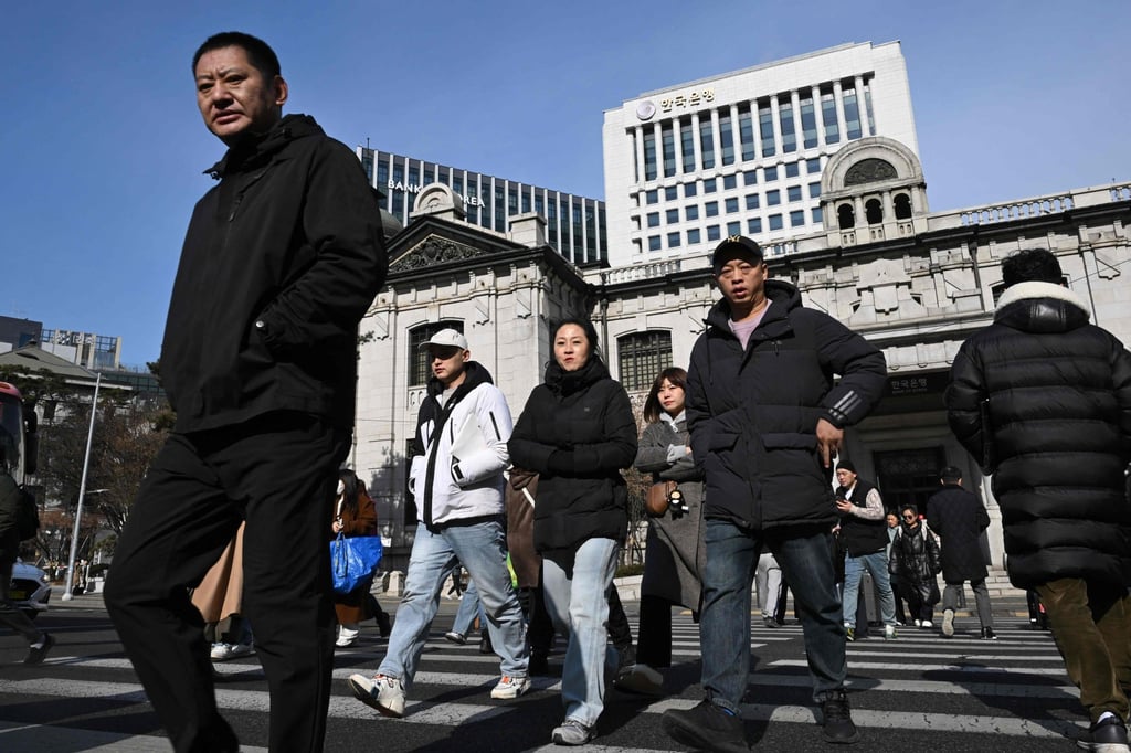Pedestrians cross a road in front of the Bank of Korea headquarters in Seoul last month. Photo: AFP Pedestrians cross a road in front of the Bank of Korea headquarters in Seoul last month. Photo: AFP