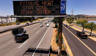 In an aerial view, a Caltrans changeable message sign on Highway 101 displays a warning about extreme heat in Corte Madera, California