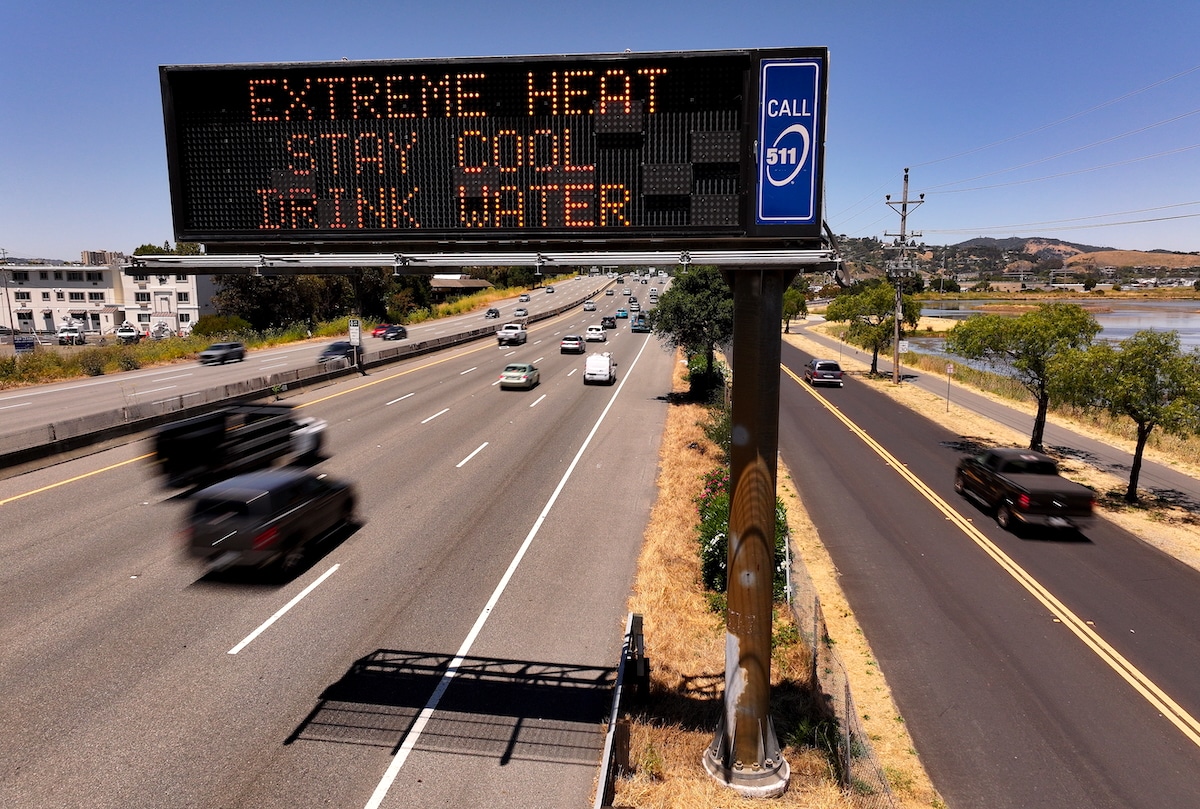 In an aerial view, a Caltrans changeable message sign on Highway 101 displays a warning about extreme heat in Corte Madera, California