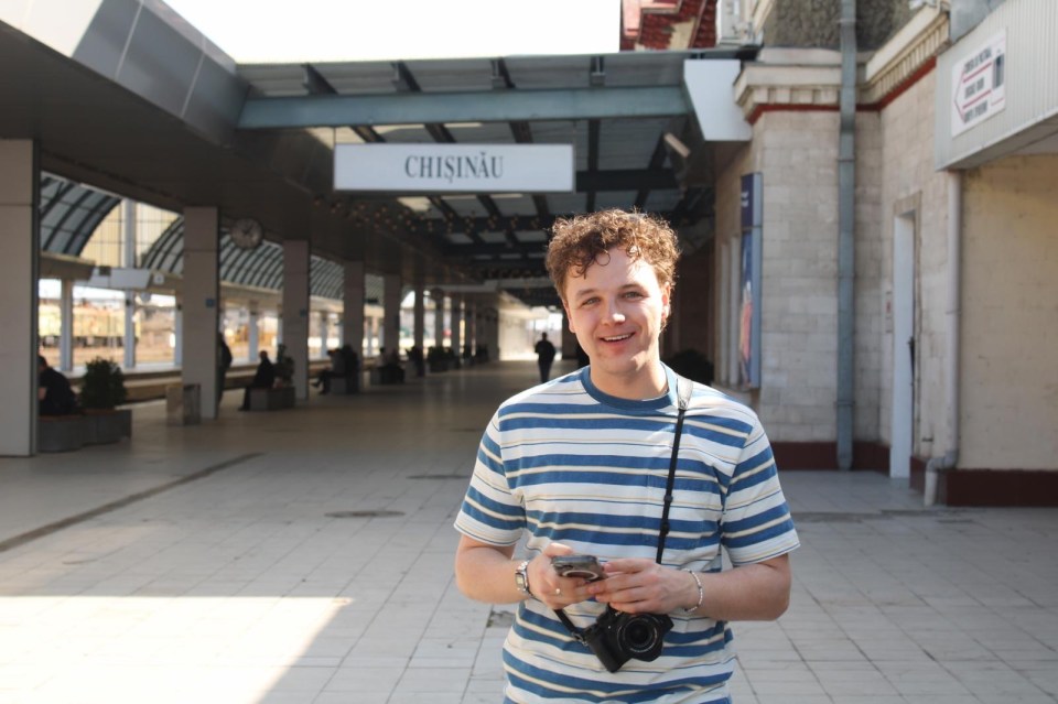 Man at Chisinau train station looking at his phone.