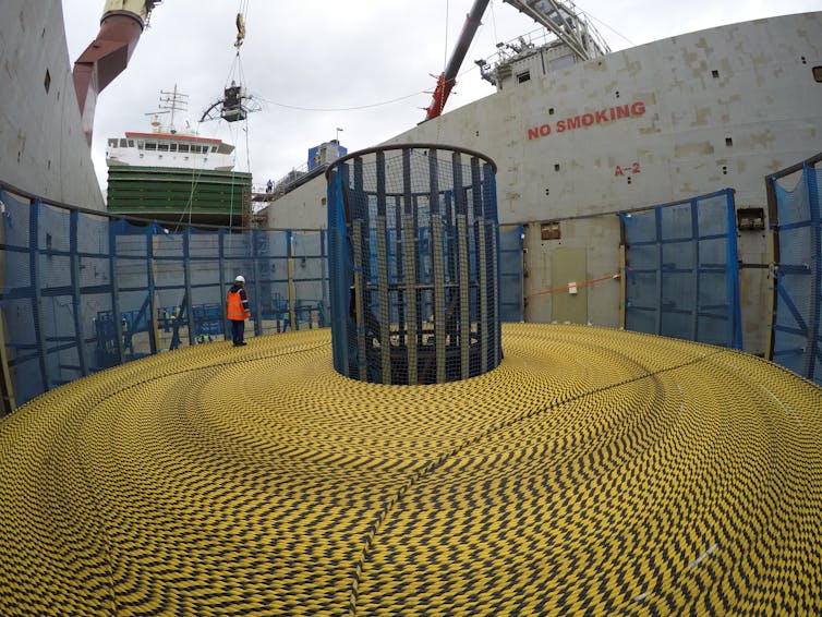 A large coil of yellow and black cable on a freight ship.