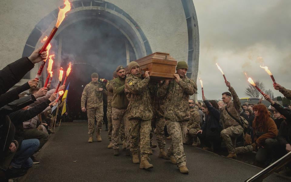 Ukrainian servicemen carry the coffin of the Hospitallers Medical Battalion volunteer and soldier Oleksandr â Bohushâ Oliynyk at a cemetery