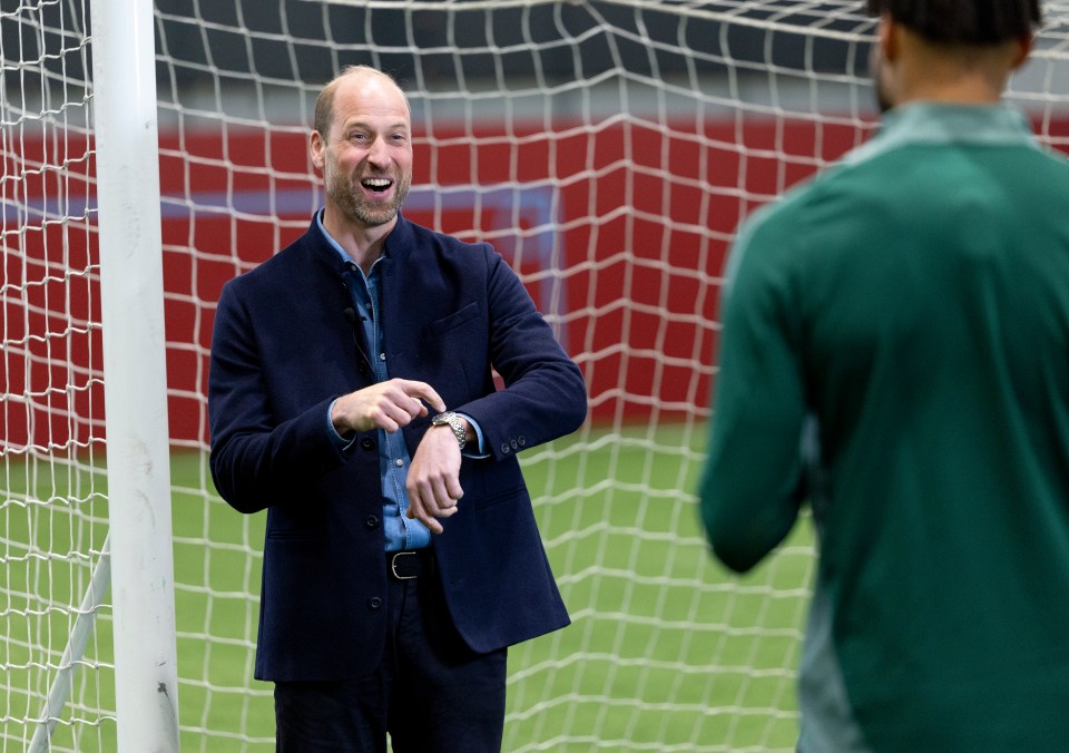 Prince William checking his watch at a soccer field.