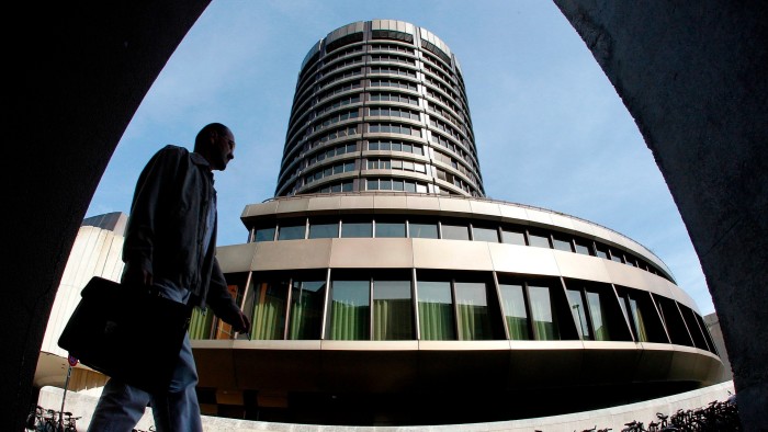 A man walks past the headquarters of the Bank for International Settlements in Basel