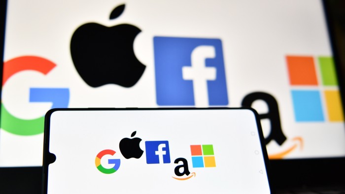 The logos of Google, Apple, Facebook, Amazon and Microsoft displayed on a mobile phone and a laptop screen