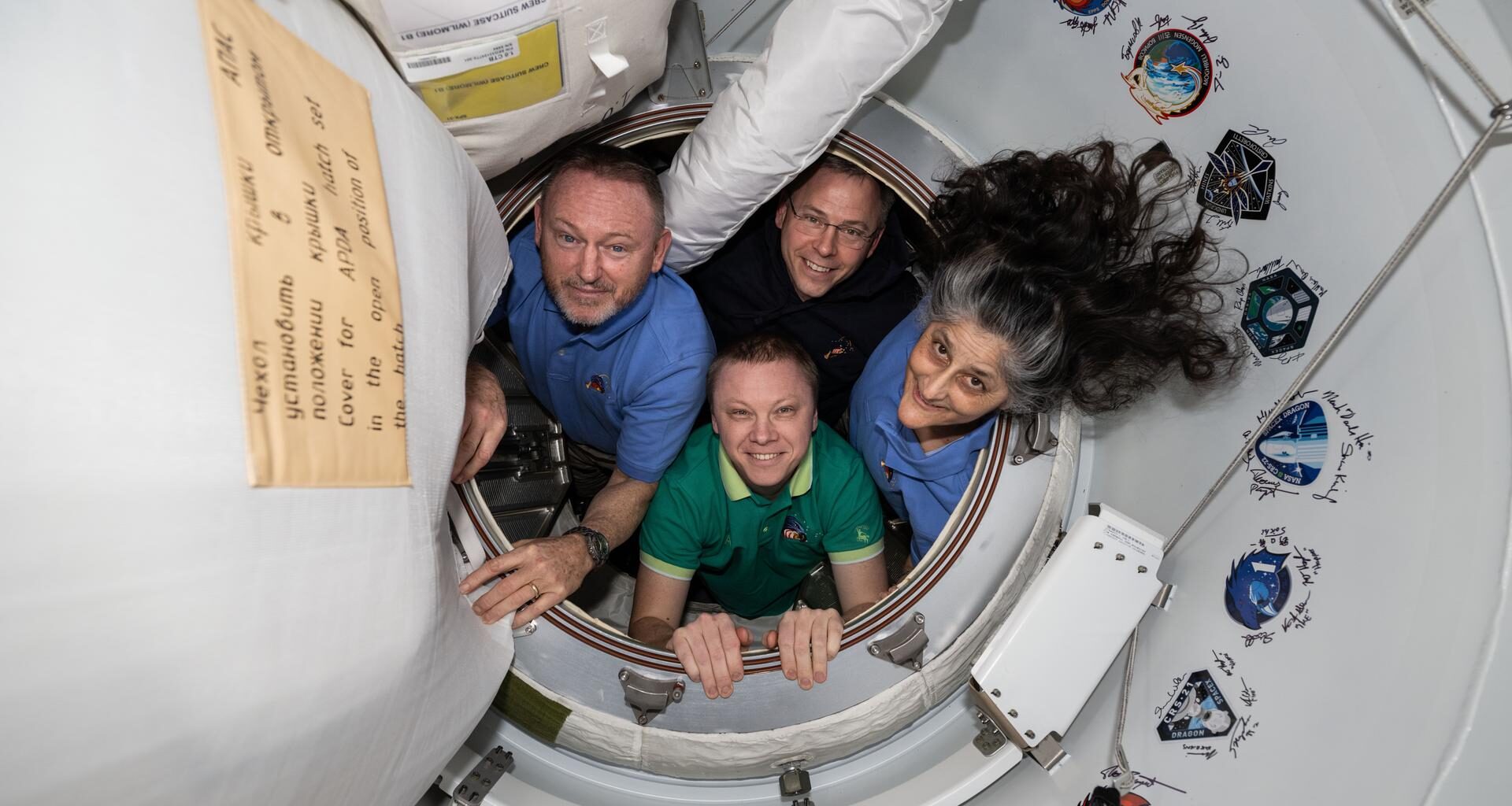 NASA's SpaceX Crew-9 members pose together for a portrait inside the vestibule between the International Space Station and the SpaceX Dragon crew spacecraft. Clockwise from left, are NASA astronauts Butch Wimore, Nick Hague, and Suni Williams, and Roscosmos cosmonaut Aleksandr Gorbunov.