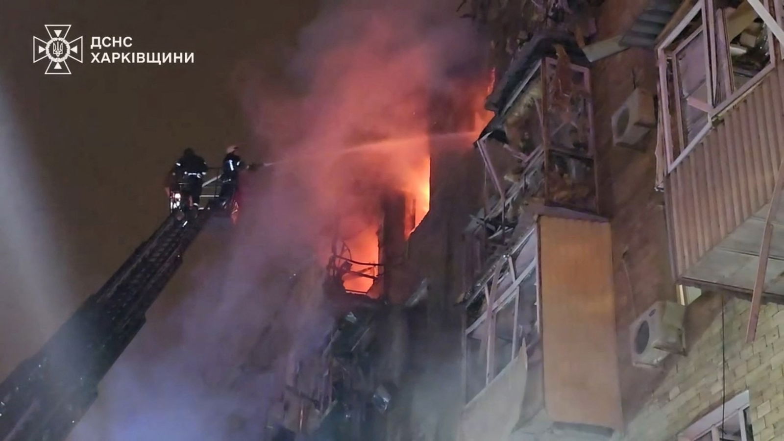 Fire fighters hose a building on fire. 