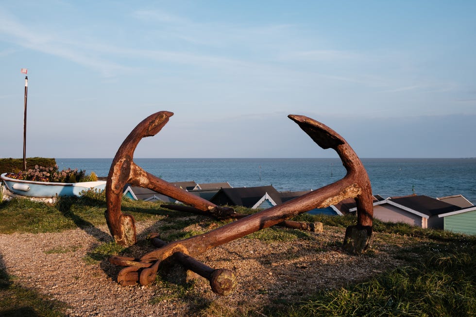 mersea island, uk may 2nd, 2021: two anchors in a glorious rust brown patina, bathed in golden light of sunset along the essex coast.