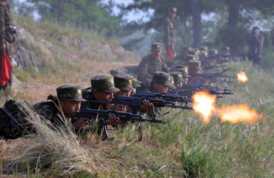 North Korean soldiers firing rifles at a range.