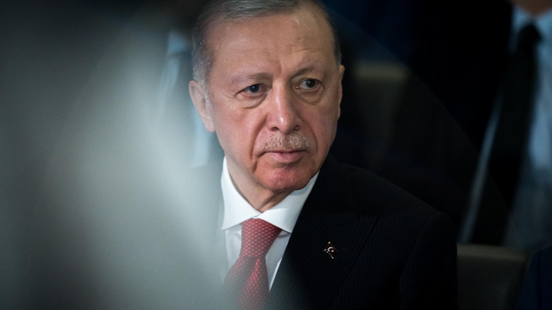 Porträt von Recep Tayyip Erdogan, der ein weißes Hemd, eine rote Krawatte und ein schwarzes Sakko trägt und an der Kamera vorbeischaut. Porträt von Recep Tayyip Erdogan, der ein weißes Hemd, eine rote Krawatte und ein schwarzes Sakko trägt und an der Kamera vorbeischaut.