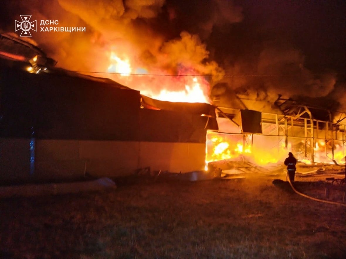 A nighttime scene is lit up orange by an apparent fire.