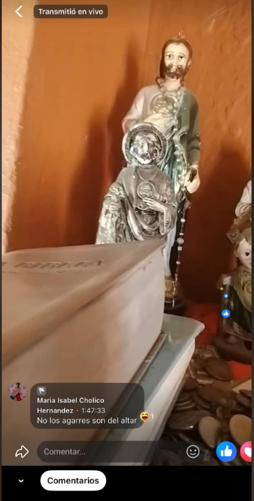 Religious figurines and coins on a table.