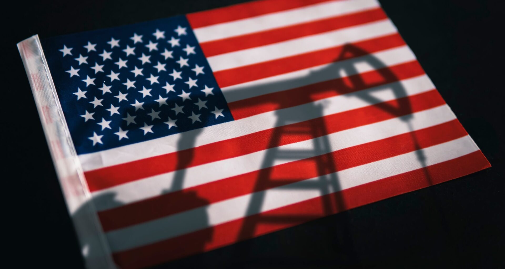 Shadow of an oil pump on the American flag, symbolizing how energy abundance isn't a climate strategy