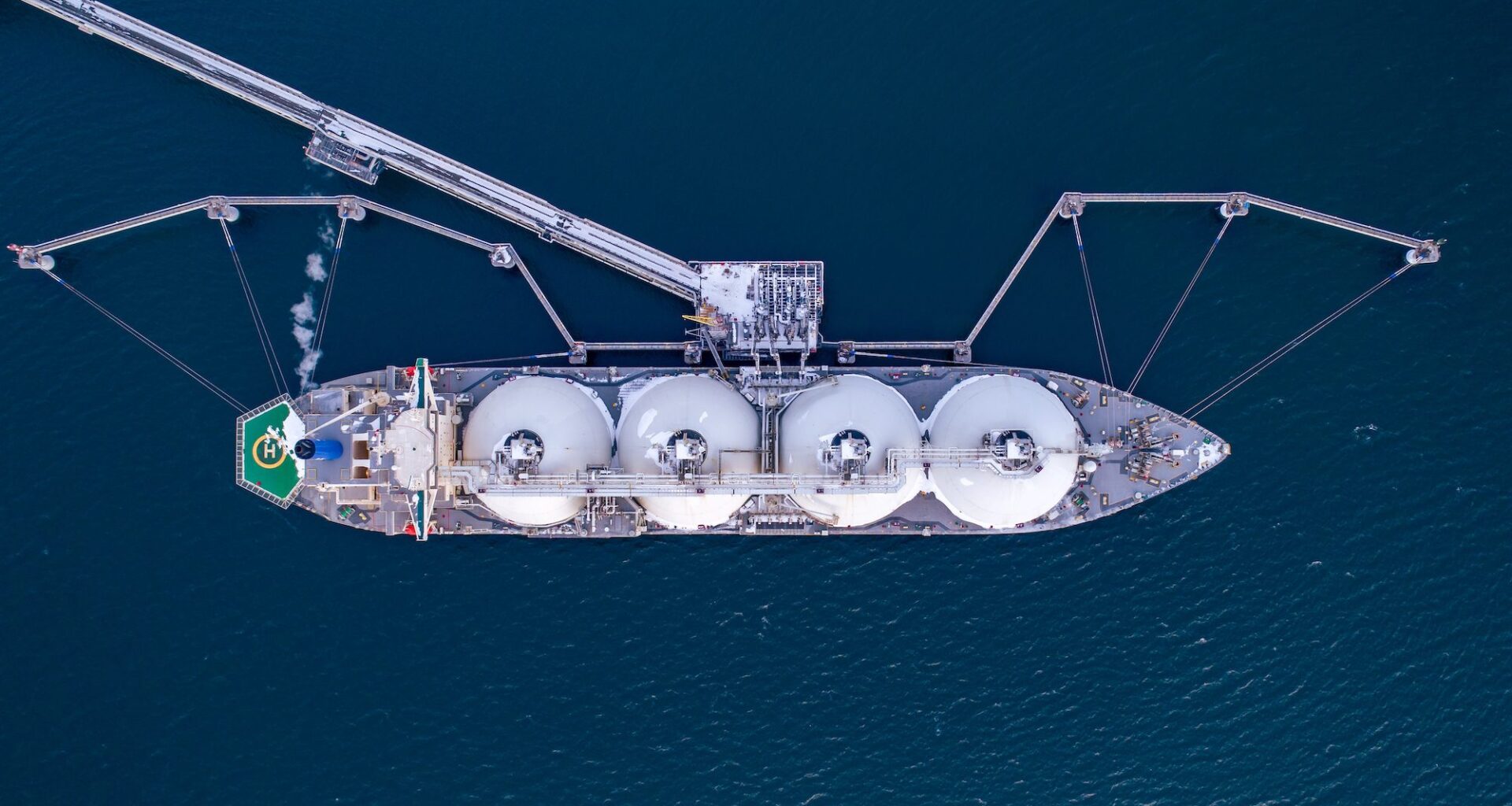 Aerial of Liquified Natural Gas LNG carrier moored to a small gas terminal