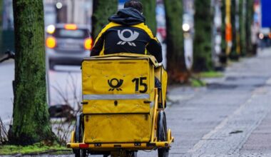 Symbolbild:Ein Briefträger fährt mit seinem Fahrrad eine Straße entlang.(Quelle:picture alliance/dpa/M.Skolimowska)
