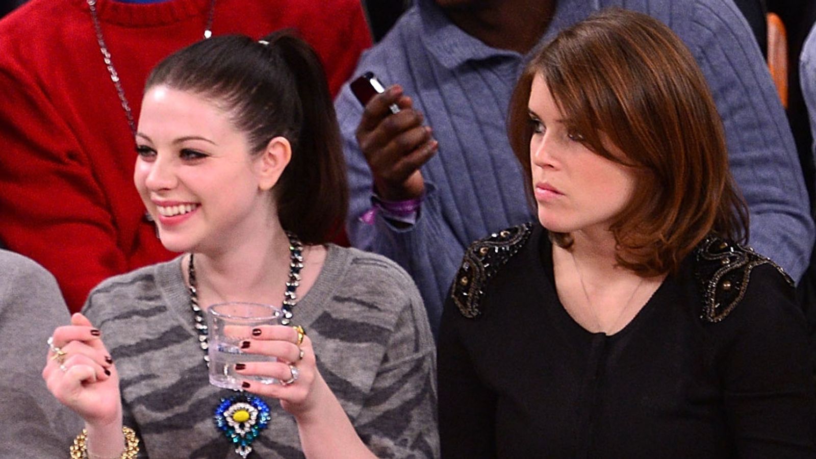 Michelle Trachtenberg and Princess Eugenie watch a basketball game in New York in December 2013. Pic: Getty/James Devaney/WireImage