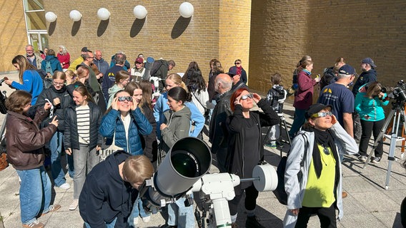 Menschen beobachten am Himmel eine Sonnenfinsterns. © Sternwarte Neumünster Foto: Marco Ludwig