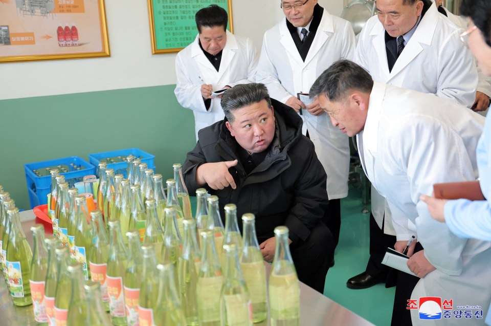 Kim Jong Un inspecting bottles of a beverage at a North Korean factory.