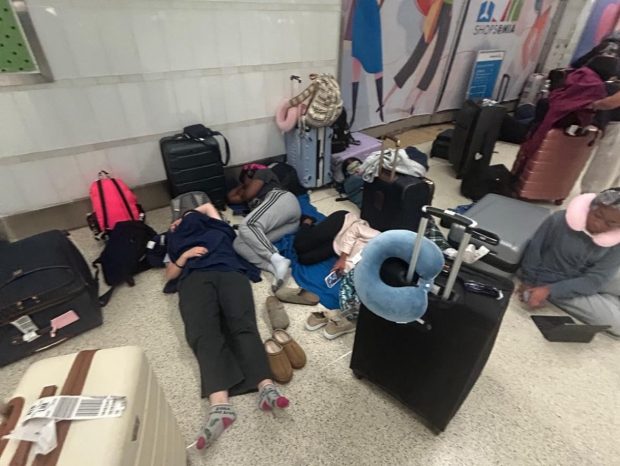 Students from Coral Springs Charter School slept on the floor at Miami International Airport Friday morning, March 21, 2025, after their flight to Athens, Greece, was canceled due to fires at Heathrow International Airport in London, where they were to have a layover. The students were unable to get on another flight that go them to Greece in time to make it on a cruise scheduled for Monday. (Allyson Dudich / Courtesy)