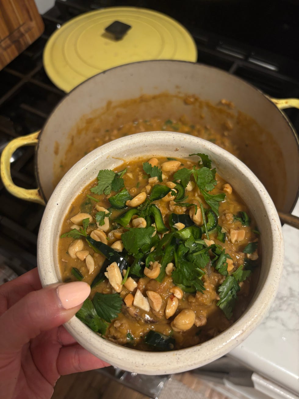writer jessica wrubel holding a bowl of three bean bison chili, a recipe in the wh high protein meal prep manual