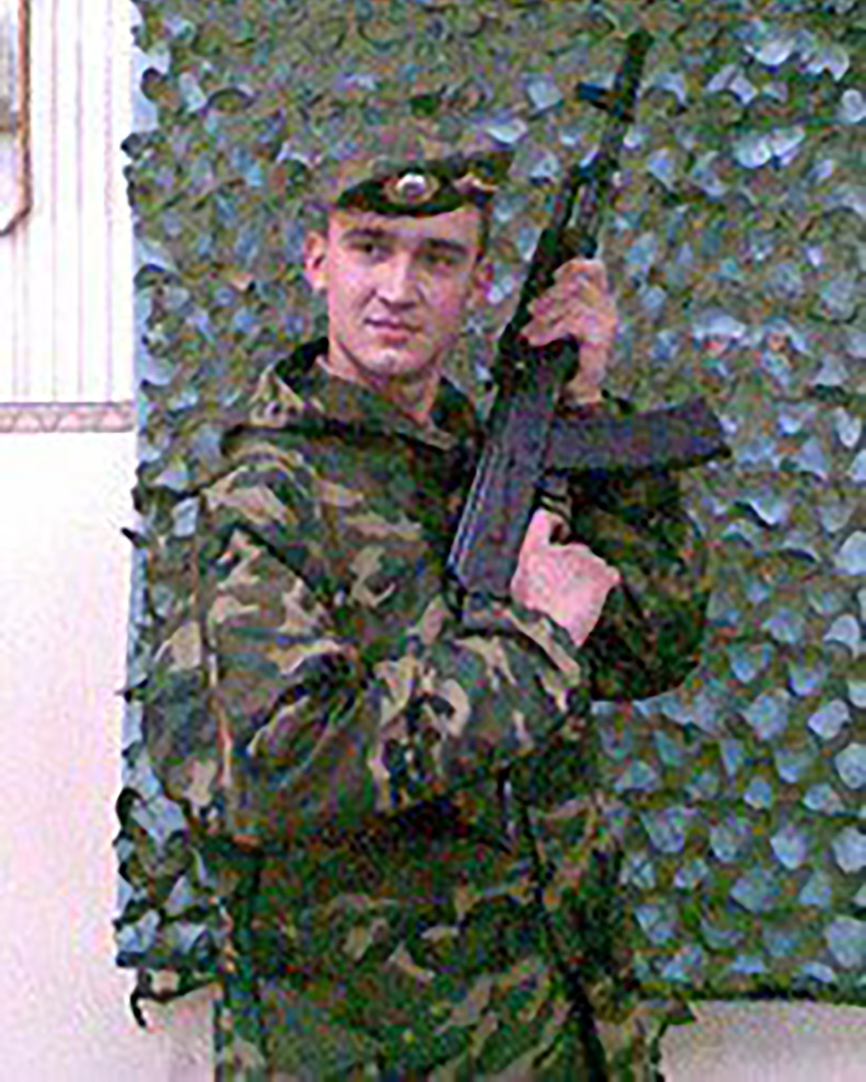 Portrait of Evgeny Kovtkov holding a rifle.