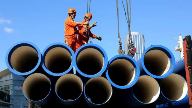 Dos trabajadores en el puerto de Lianyungang, en China.
