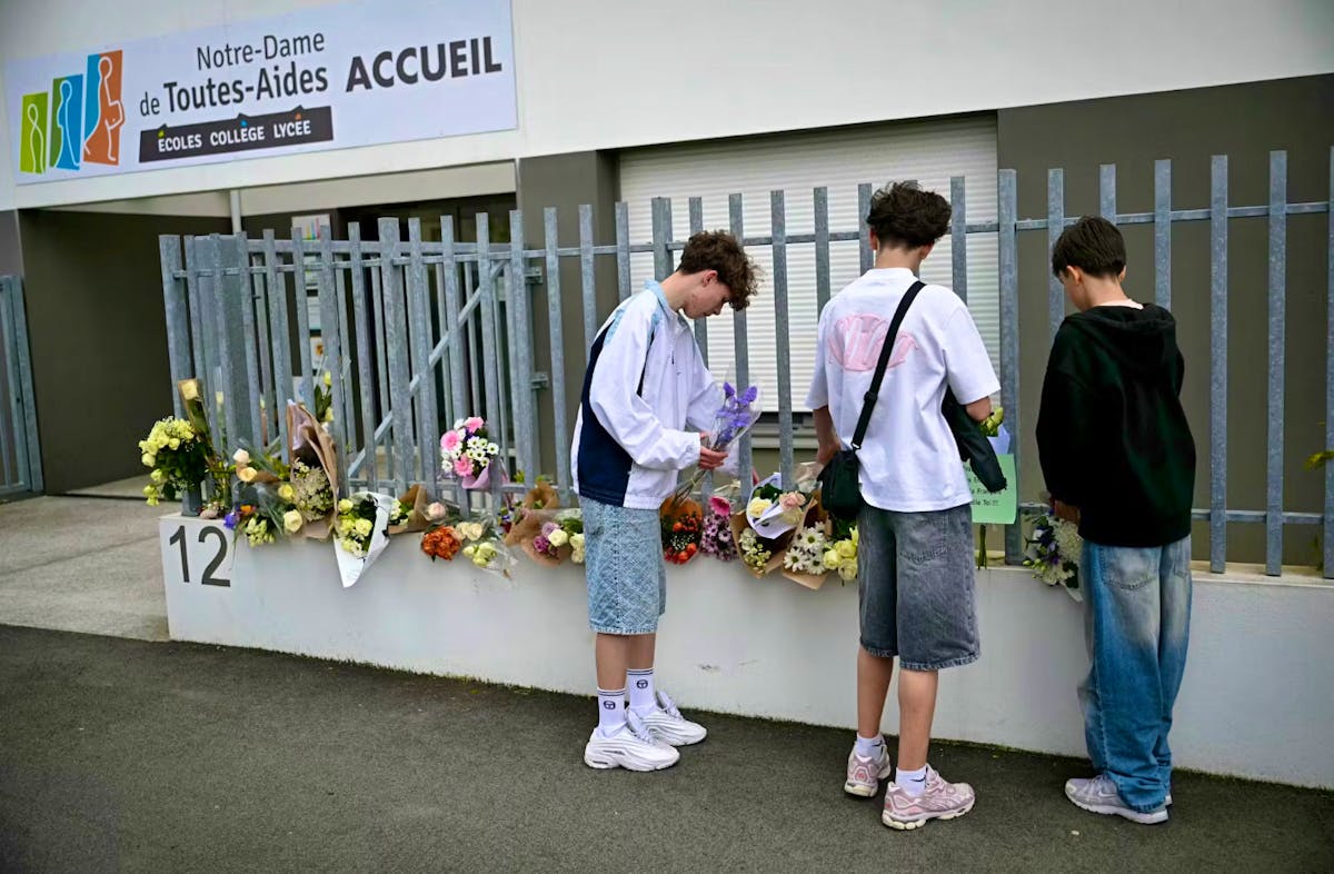 Des lycéens viennent déposer des fleurs devant l'établissement où s'est déroulé le drame.
