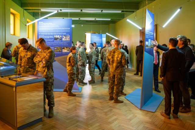 U.S. service members and other attendees explore the new exhibit titled “Message Follows” following its opening at the Latvian War Museum in Riga, Latvia, April 11, 2025. The exhibit showcases video interviews, uniforms, equipment, and...