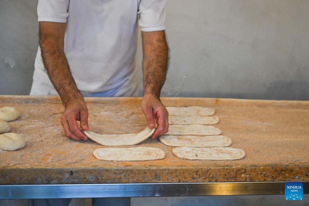 Cooks prepare pides at restaurant in Bursa, Türkiye-Xinhua