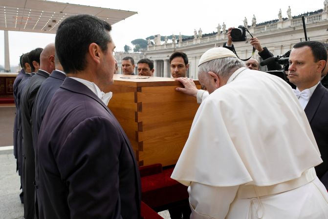 Pope Francis touches the coffin of former Pope Benedict XVI in January 2023. <a href=