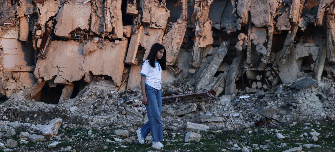 A girl walks amid widespread destruction in Aleppo, Syria, left behind after 14 years of war.
