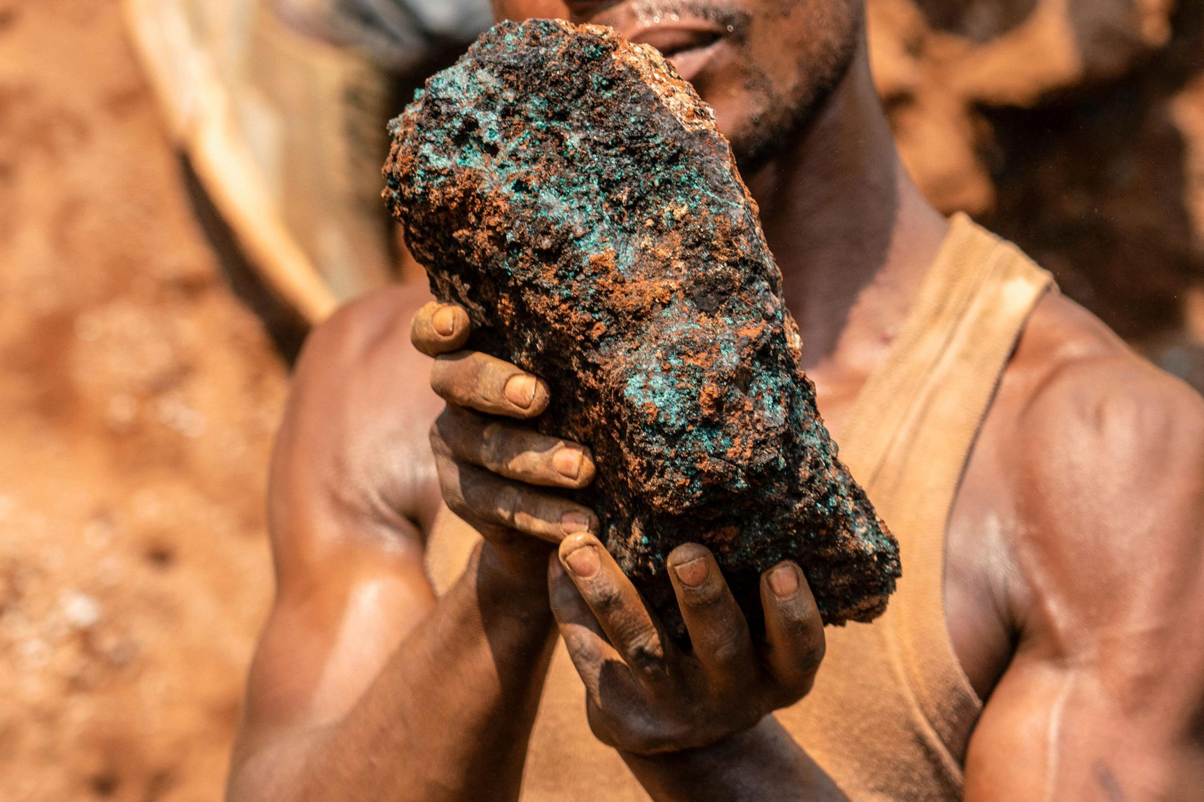 Dela wa Monga, an artisanal miner, holds a cobalt stone at the Shabara artisanal mine near Kolwezi on October 12, 2022. - Some 20,000 people work at Shabara, in shifts of 5,000 at a time..Congo produced 72 percent of the worlds cobalt last year,