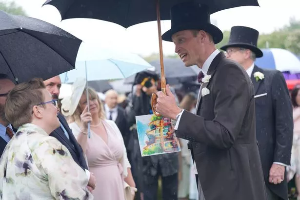 Prince William holds a gift he received during the garden party