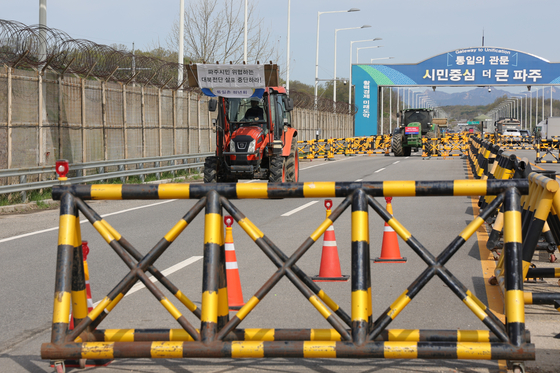 Residents of Tongilchon, a village inside the civilian control zone, cross Tongil Bridge driving tractors to stage a protest against the Families of Abductees to North Korea Association’s attempt to launch anti-North Korea leaflets at Imjingak in Paju, Gyeonggi, on April 23. [YONHAP]