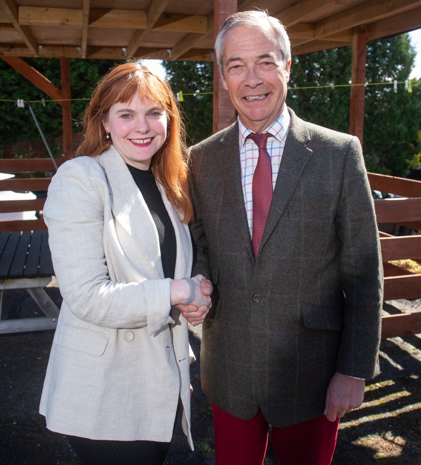 Nigel Farage shaking hands with a woman.