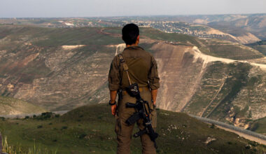 An Israeli soldier stands at a lookout point in the Israel-annexed Golan Heights overlooking south Syria, on March 25, 2025