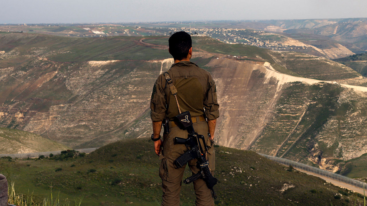 An Israeli soldier stands at a lookout point in the Israel-annexed Golan Heights overlooking south Syria, on March 25, 2025