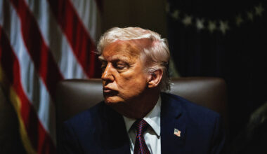 Portrait of US President Donald Trump sat in shadow during a cabinet meeting at the White House.